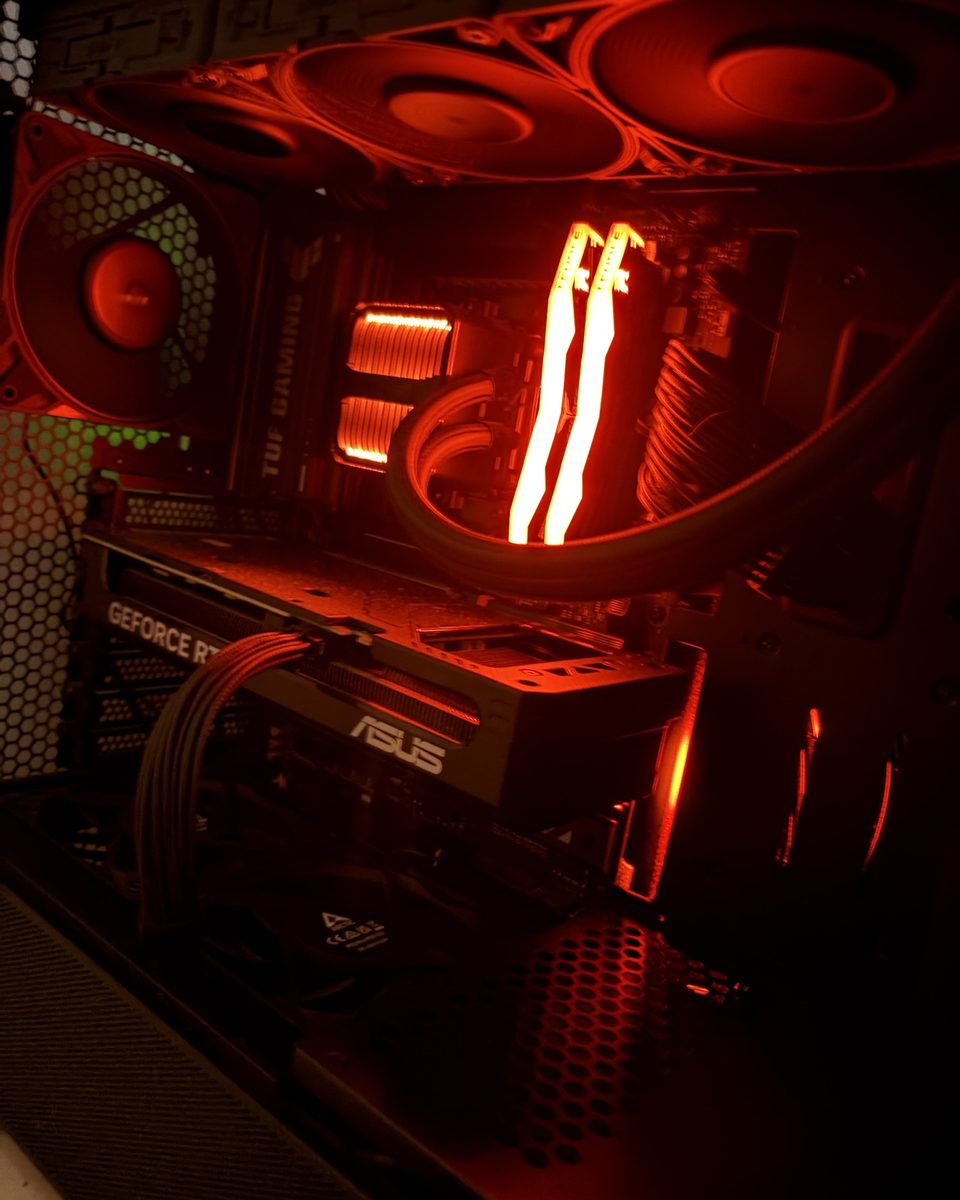 Black PC build with orange lighting, AIO cooler and sleeved cables